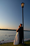 Romantic wedding photograph of a bride and groom near the shore at sunset